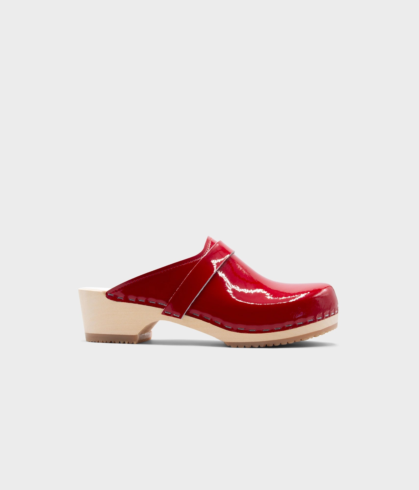 Red leather clog mule on a light gray background