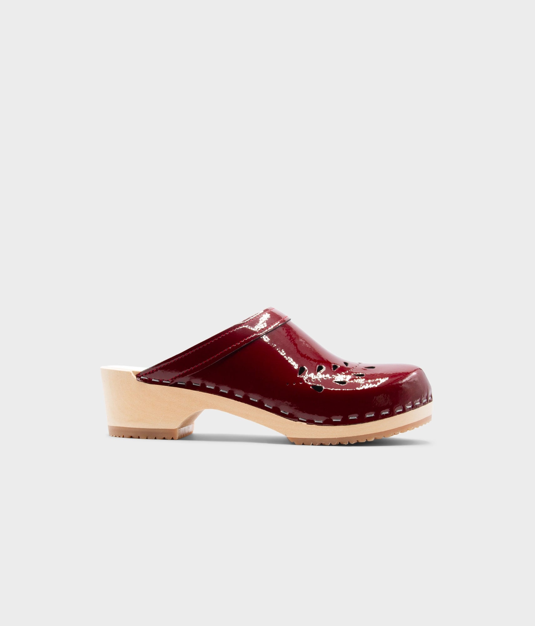 Single maroon clog shoe on a light gray background