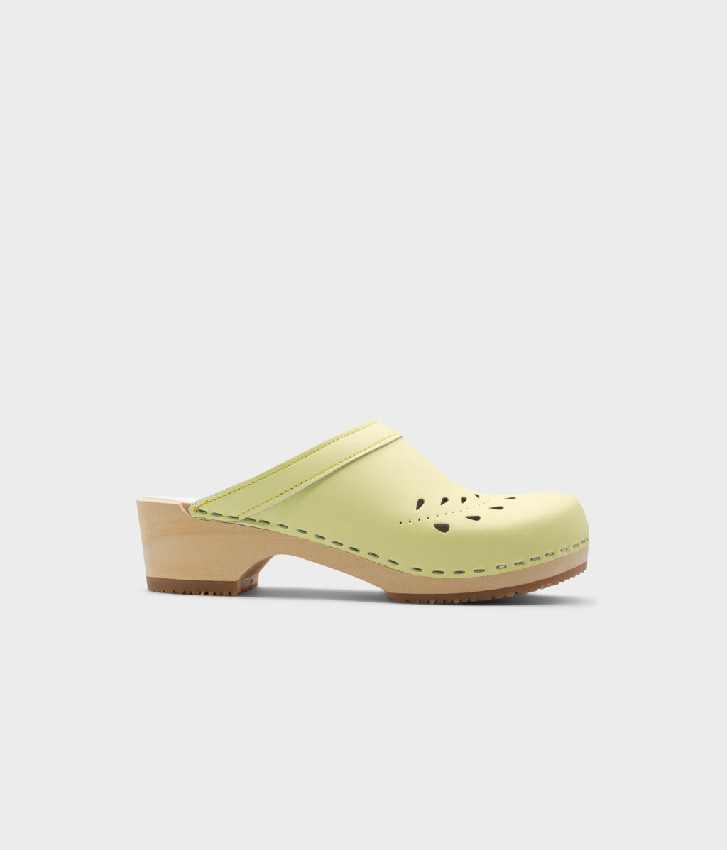 Light green clog shoe on a white background