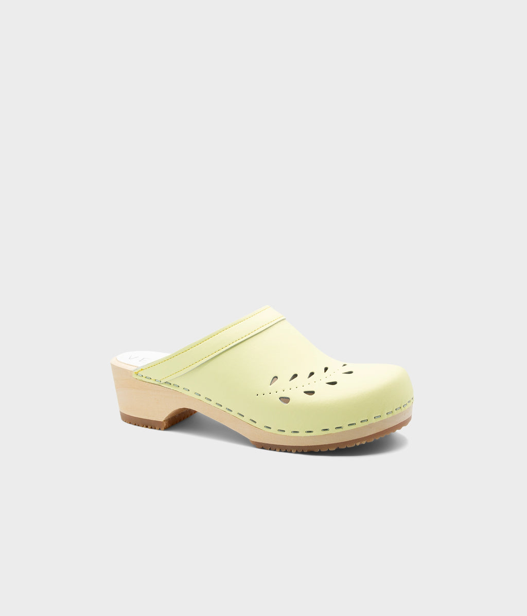 Light green clog shoe on a white background