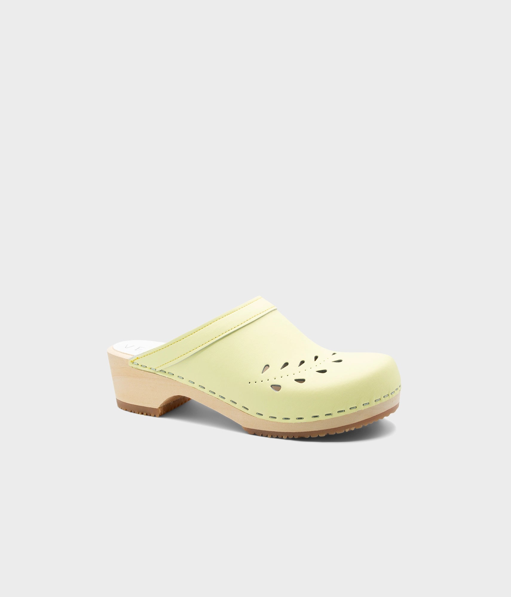 Light green clog shoe on a white background