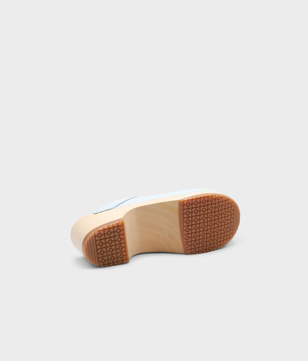 Close-up of a shoe sole with a wooden finish on a light gray background