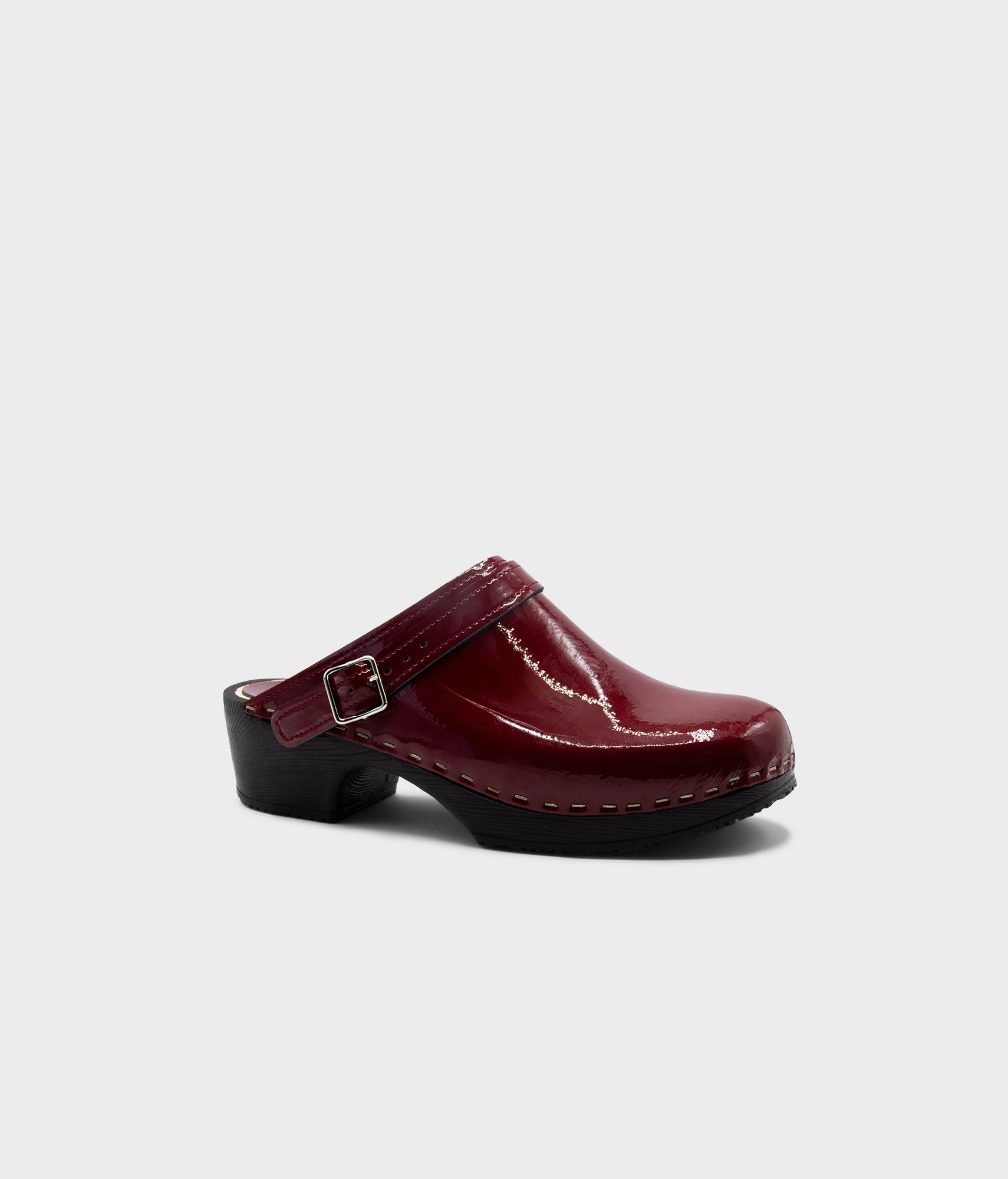 Maroon clog shoe on a light gray background