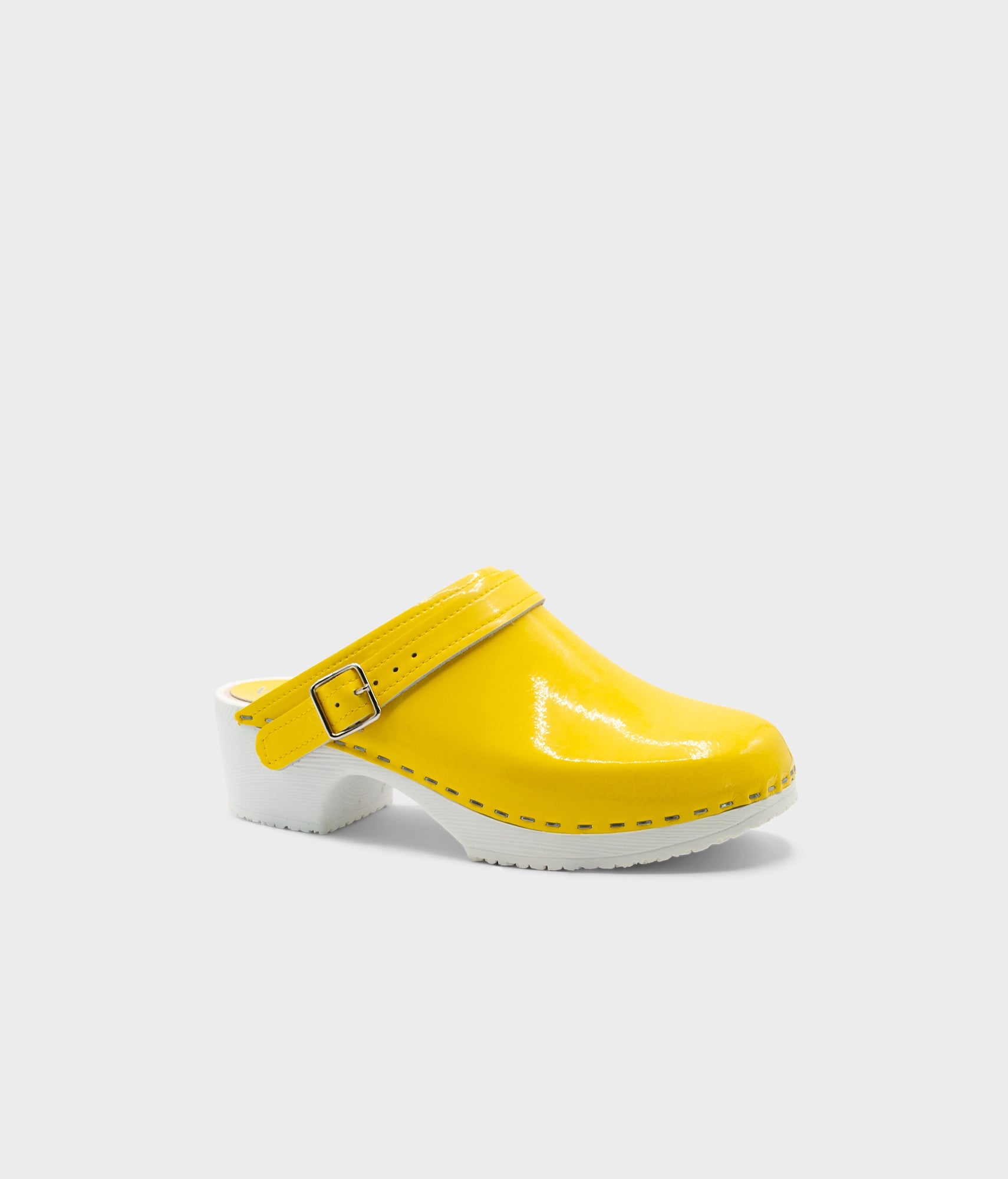 Yellow clog shoe with a white sole on a light gray background