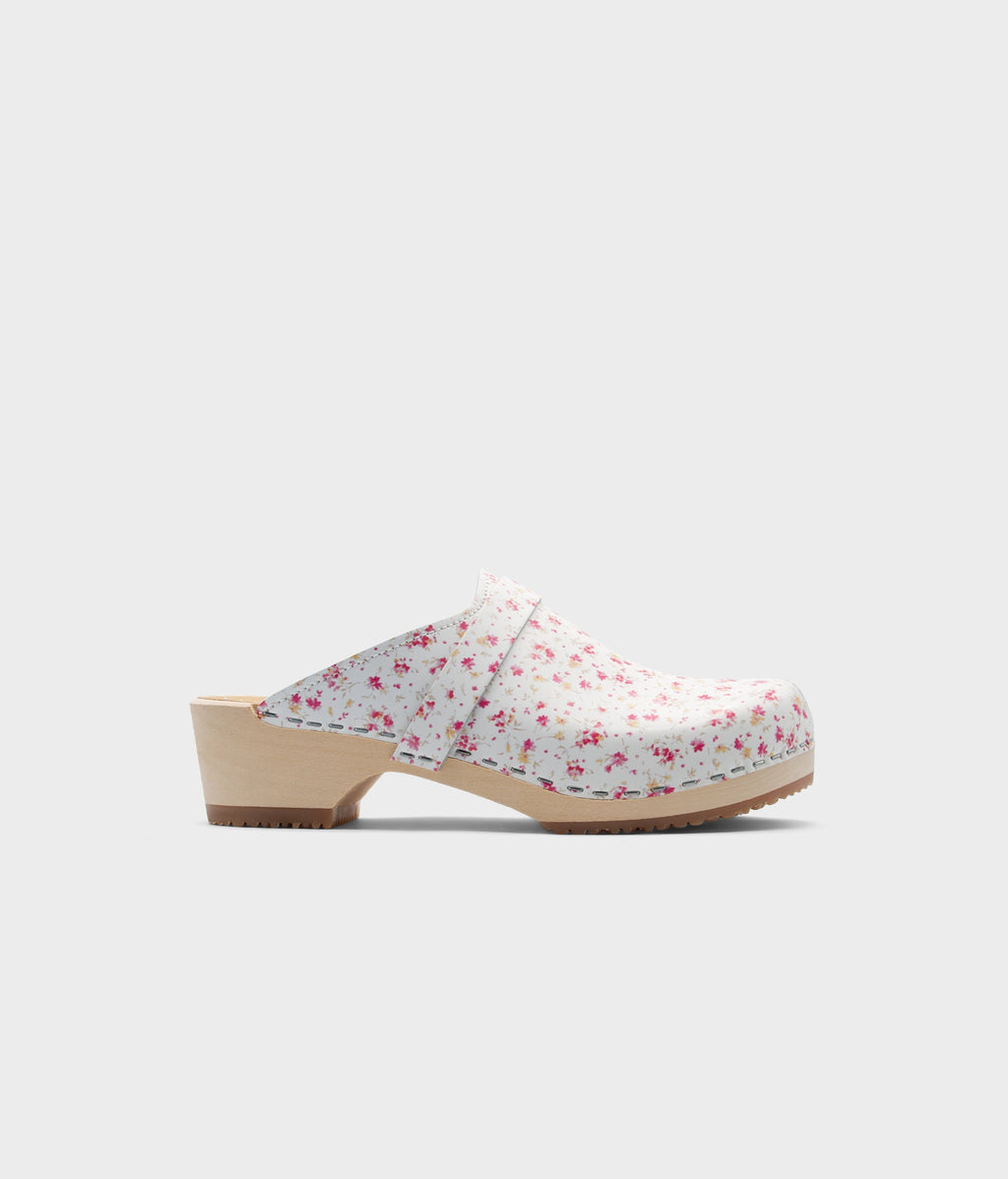 Floral-patterned wooden clog shoe on a light gray background