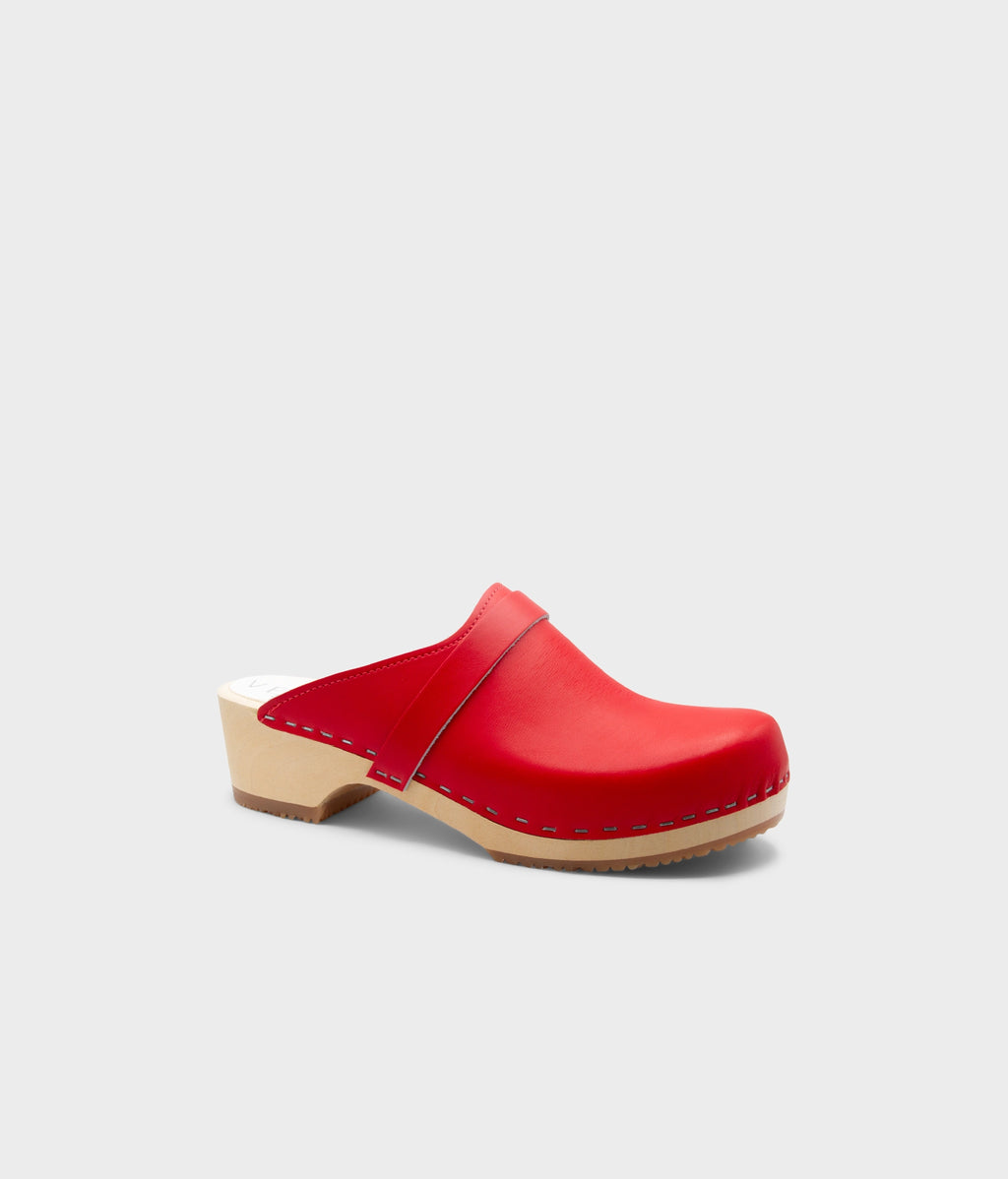 Red wooden clog shoe on a light gray background