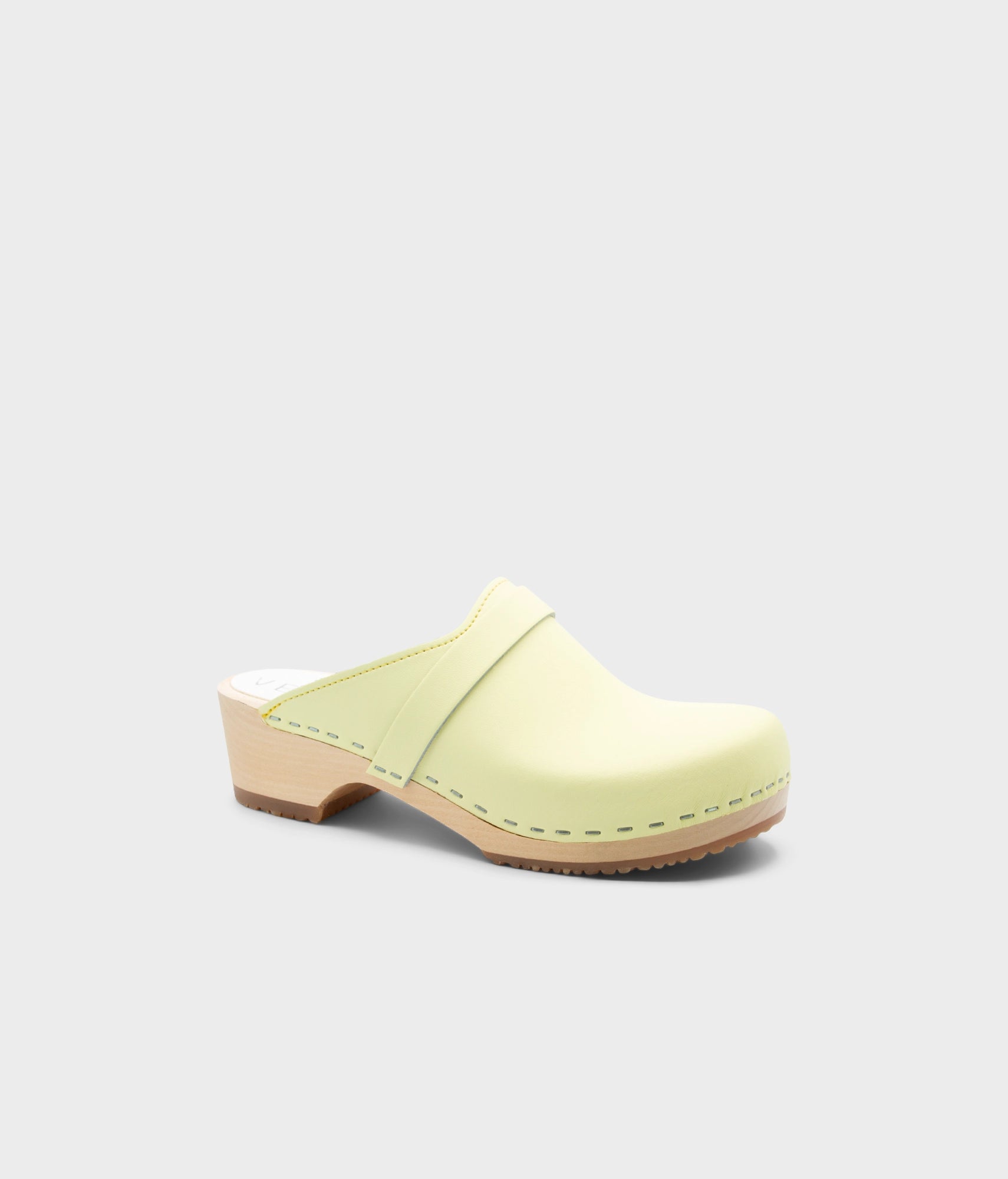 Light yellow clog mule on a light gray background