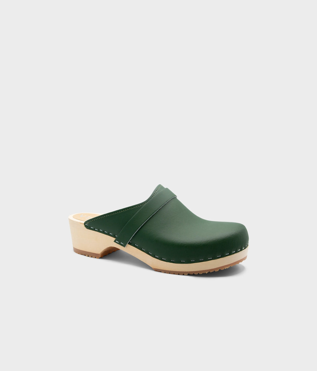 Green clog muleon a light gray background