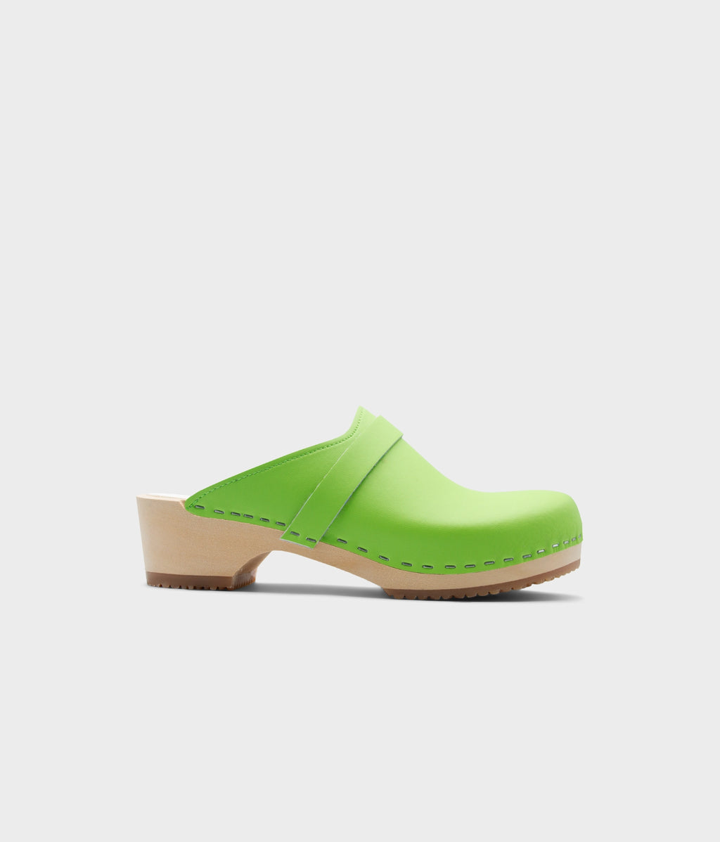 Green clog shoe on a light gray background