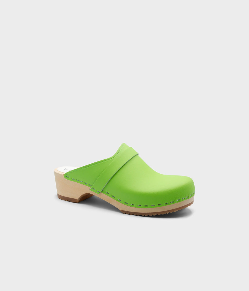 Green clog shoe on a light gray background