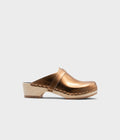Bronze clog shoe on a light gray background