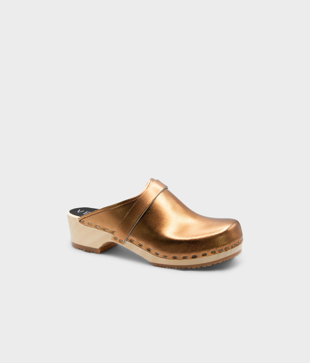 Bronze-colored wooden clog shoe on a light gray background