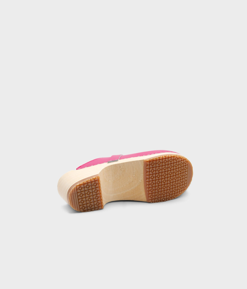 Pink shoe sole with a brown sole on a light gray background