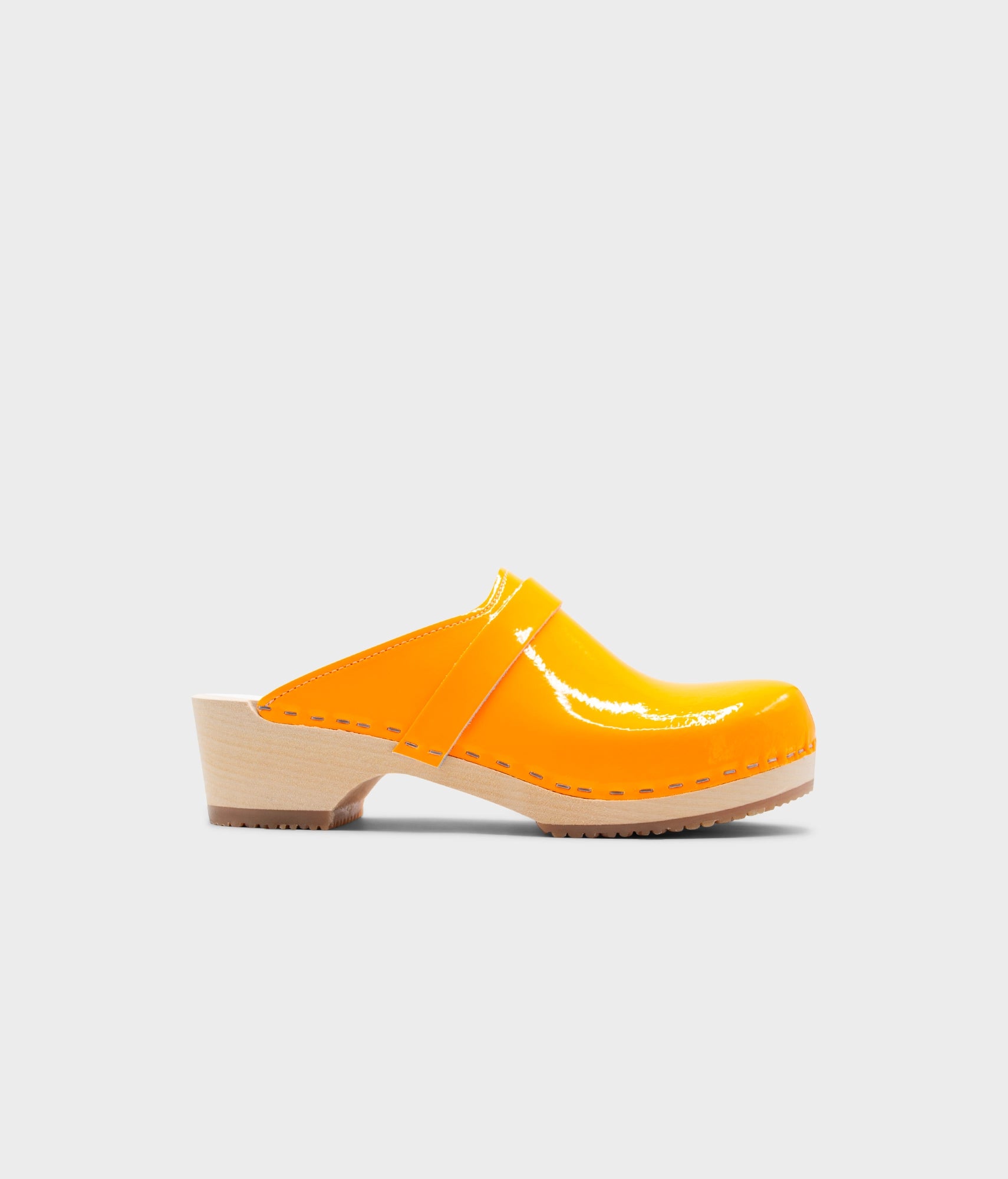 Yellow clog shoe on a light gray background