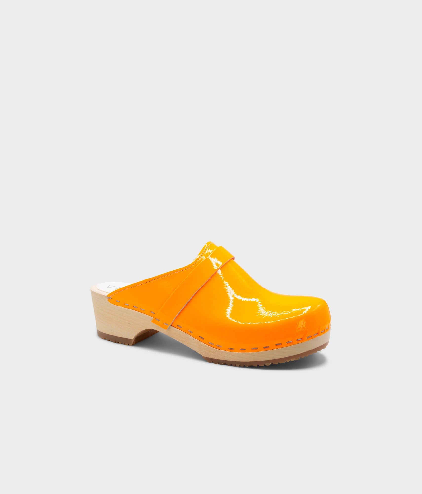 Orange clog shoe on a light gray background