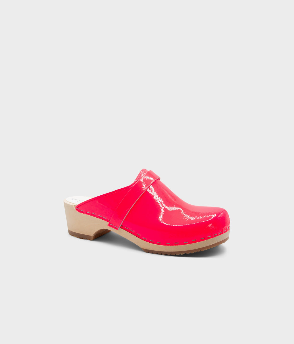 Single pink clog shoe on a light gray background