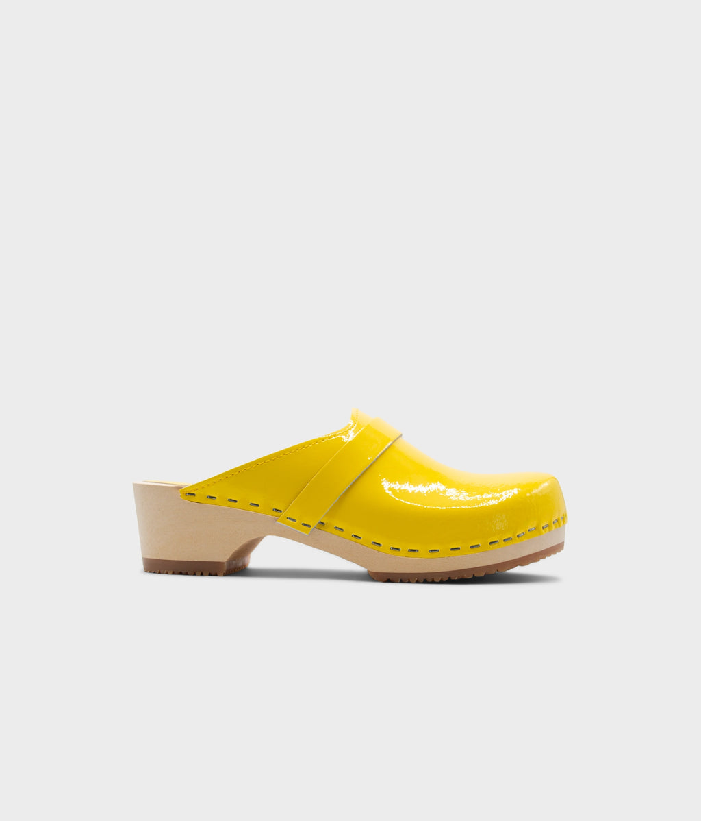 Yellow clog mule on a light gray background