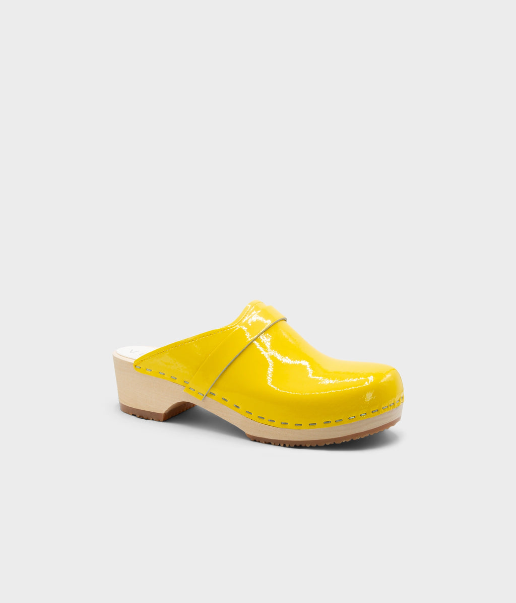 Yellow clog mule on a light gray background