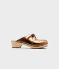 Bronze clog shoe on a light gray background