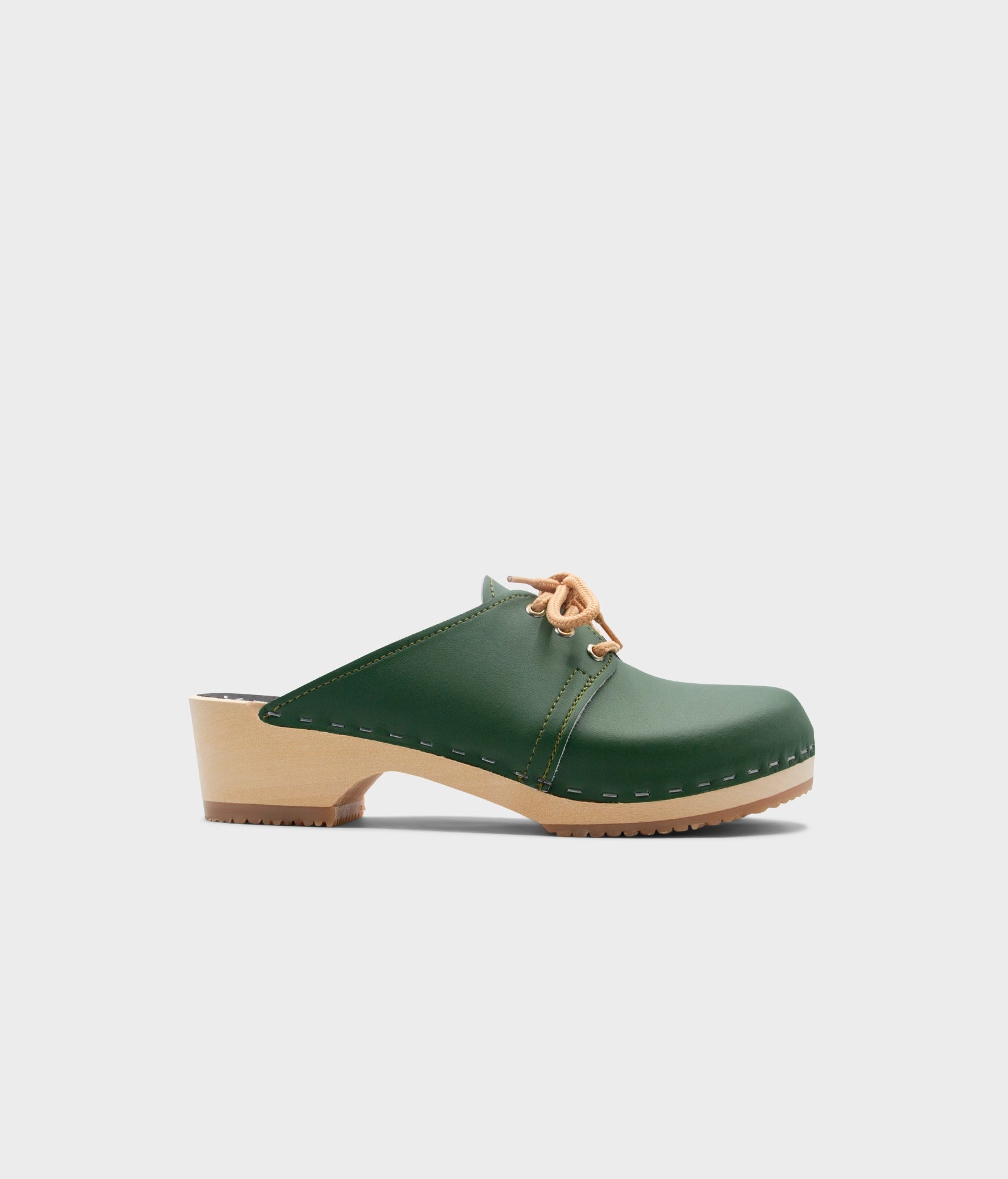 Green clog shoe on a light gray background