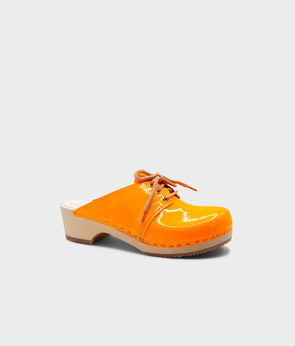 Orange clog shoe on a light gray background