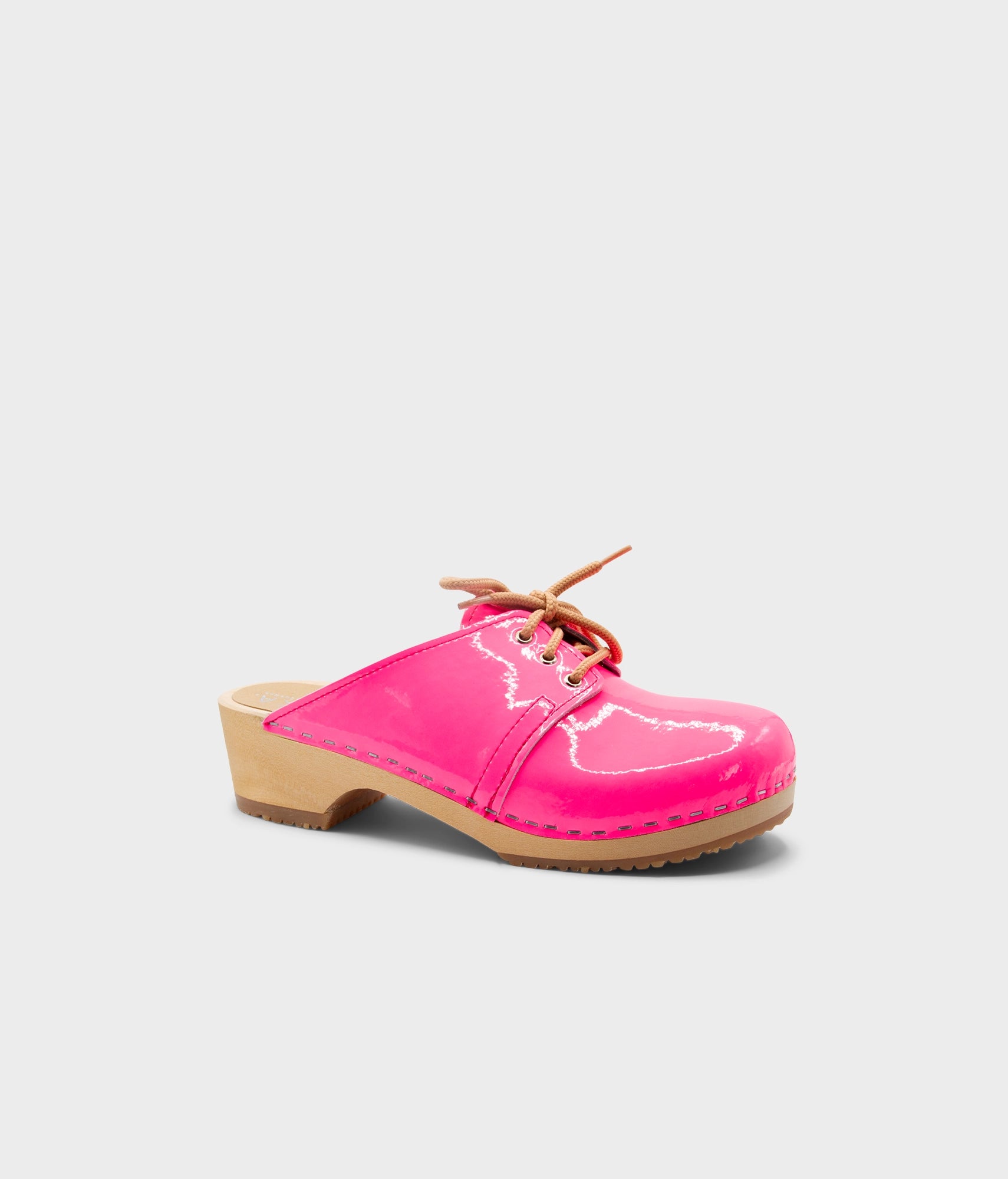 Pink clog shoe with wooden sole on a light gray background