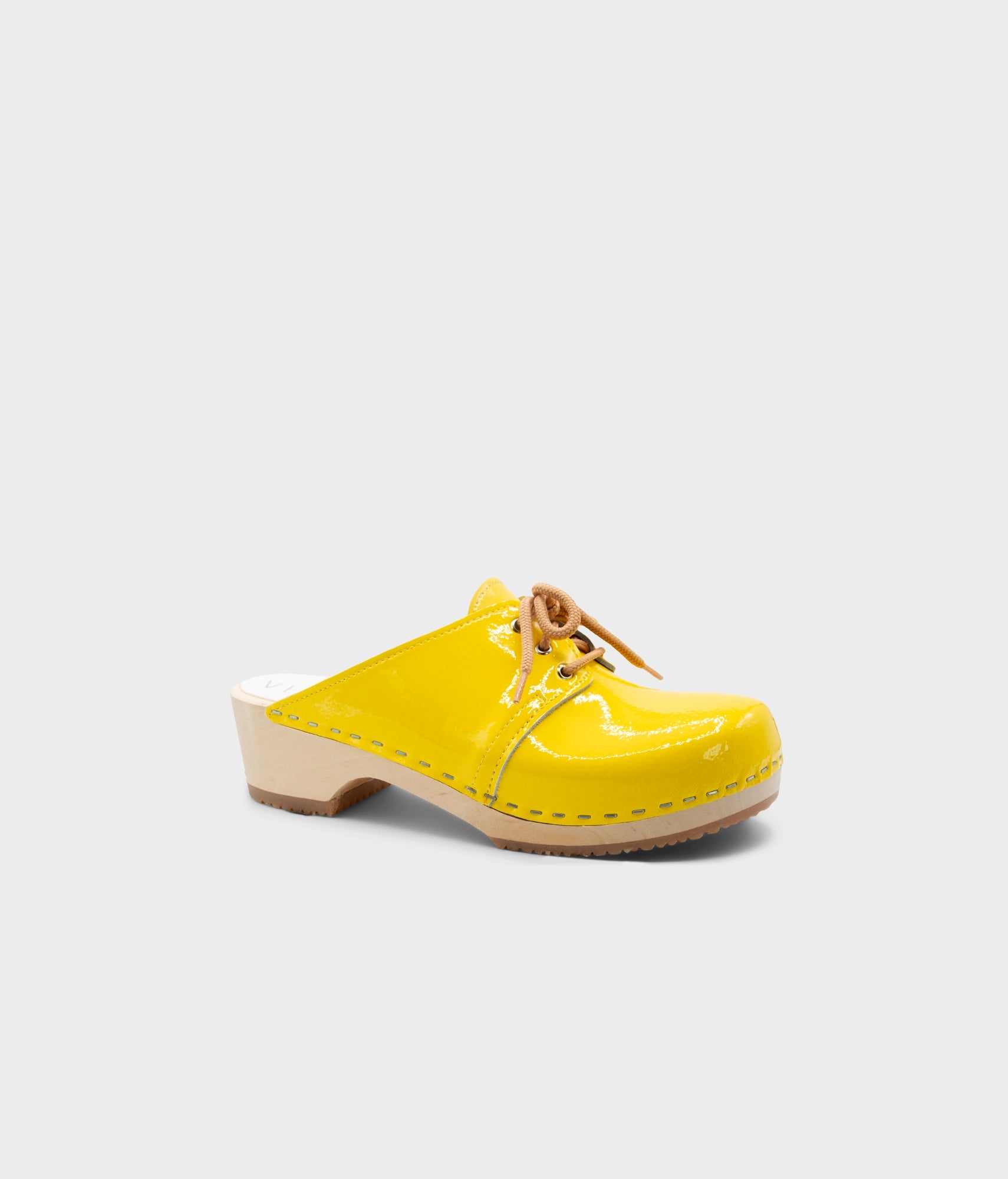 Yellow clog shoe on a light gray background