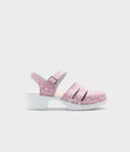 A single pink clog sandal with white polka dots on the upper and a chunky white sole, shown from a side profile against a light gray background.