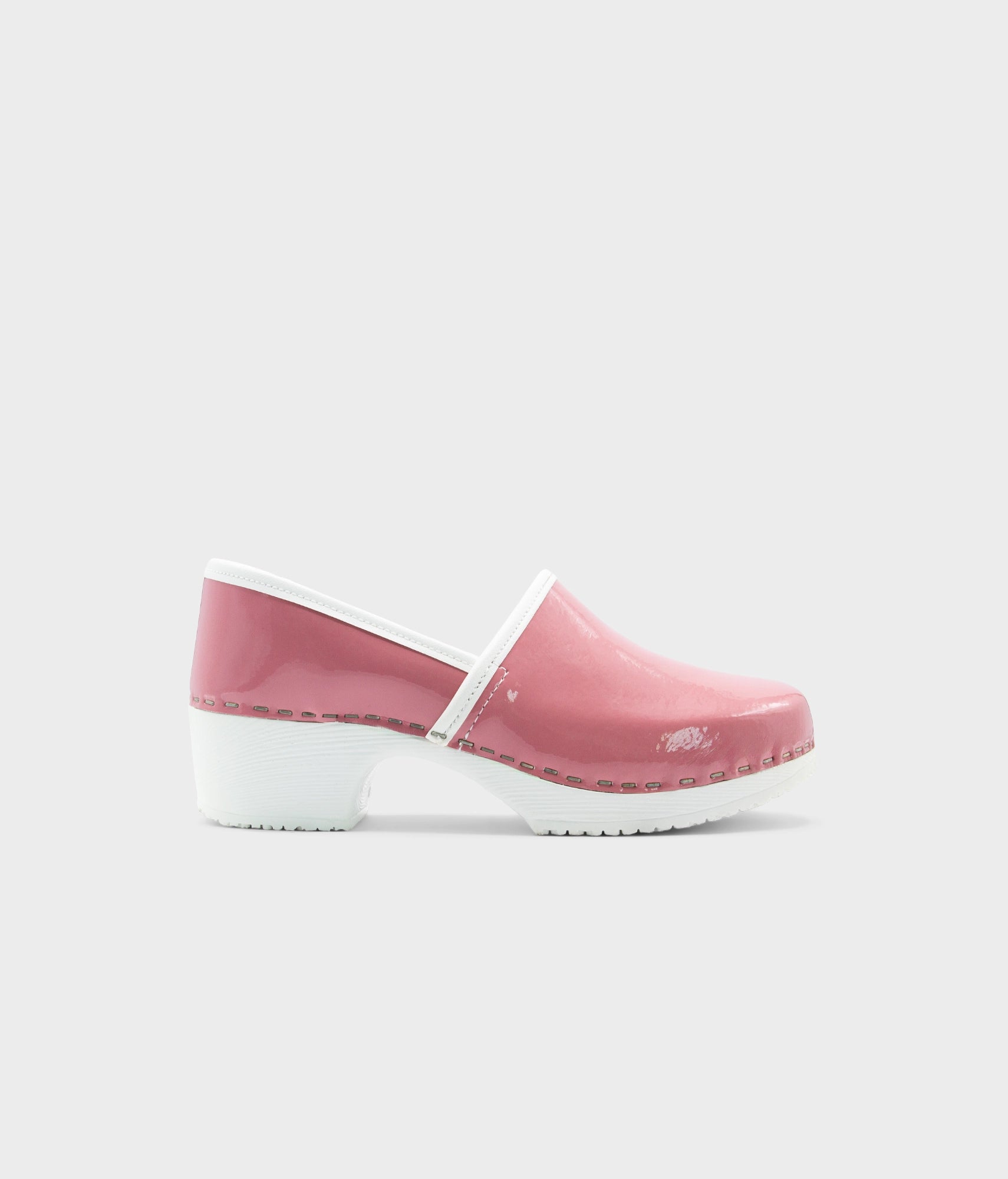 Pink clog shoe with white sole on a light gray background