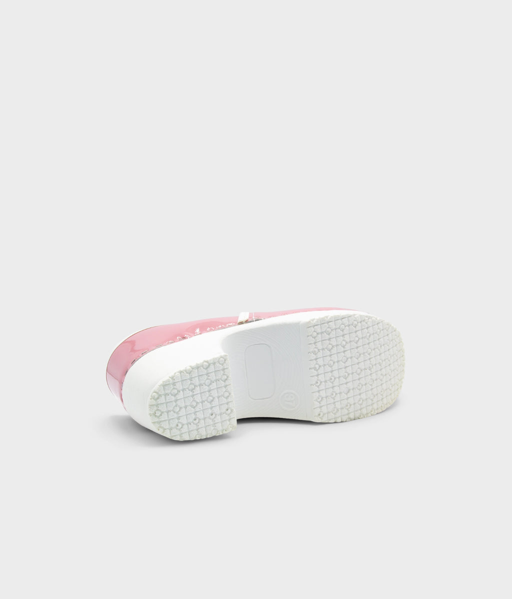 Pink sneaker with white sole on a light gray background