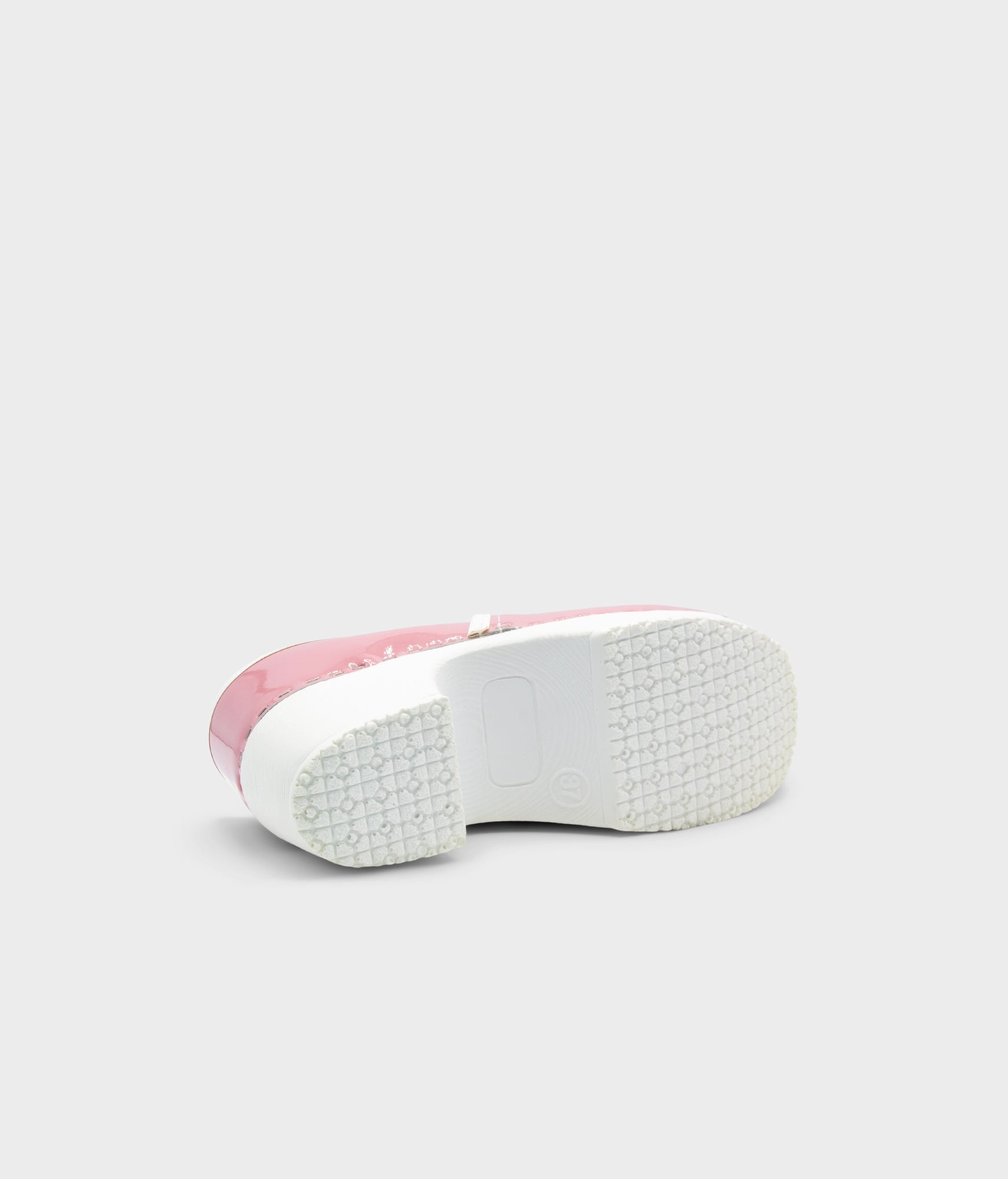Pink sneaker with white sole on a light gray background