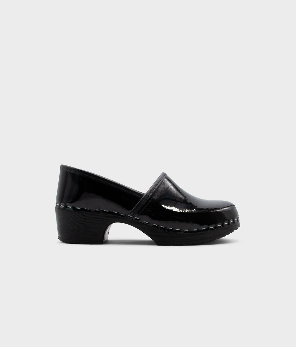 Black patent leather clog shoe on a white background