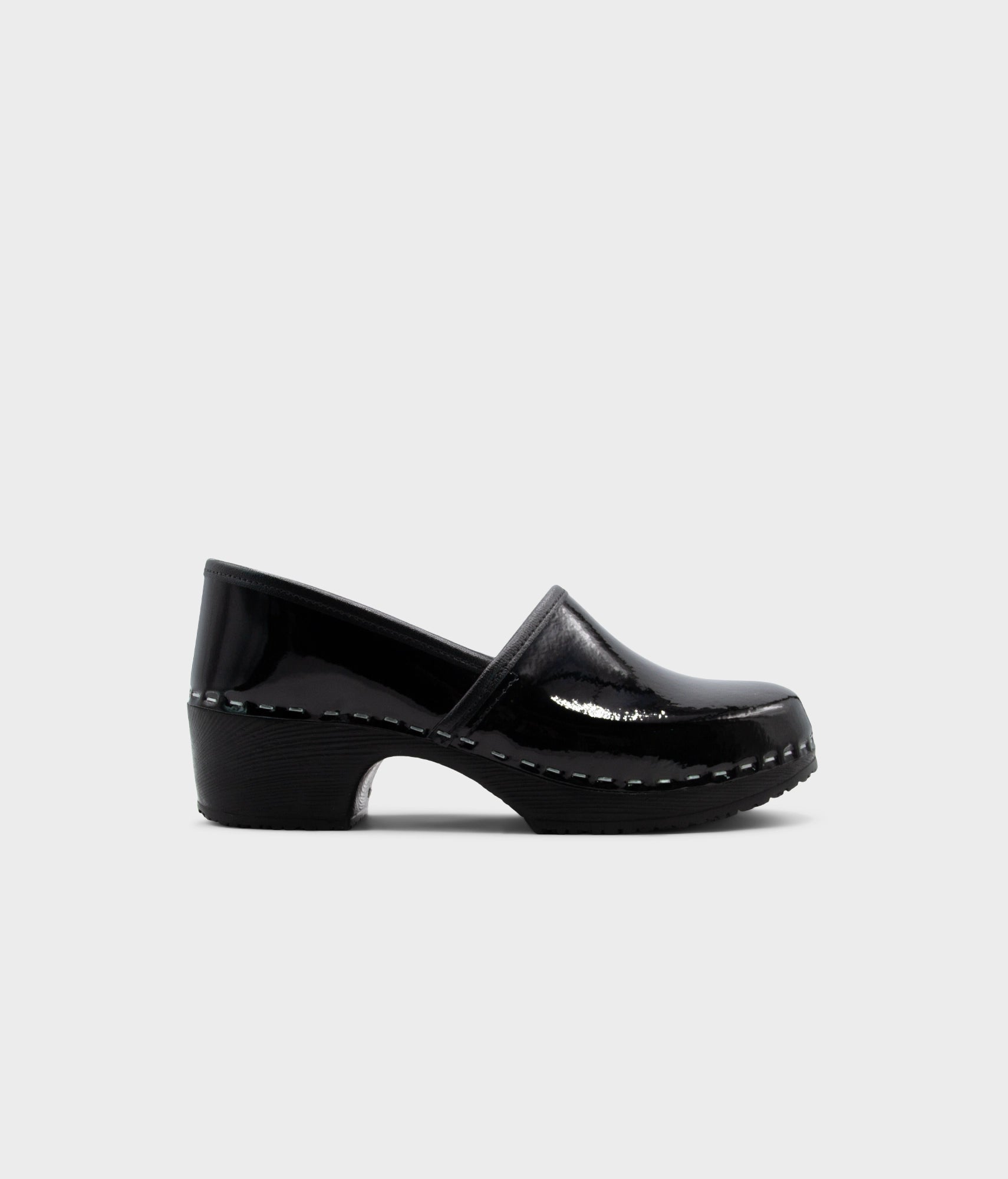 Black patent leather clog shoe on a white background