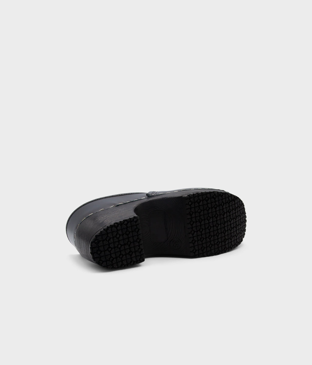 Black rubber sole of a shoe on a light gray background