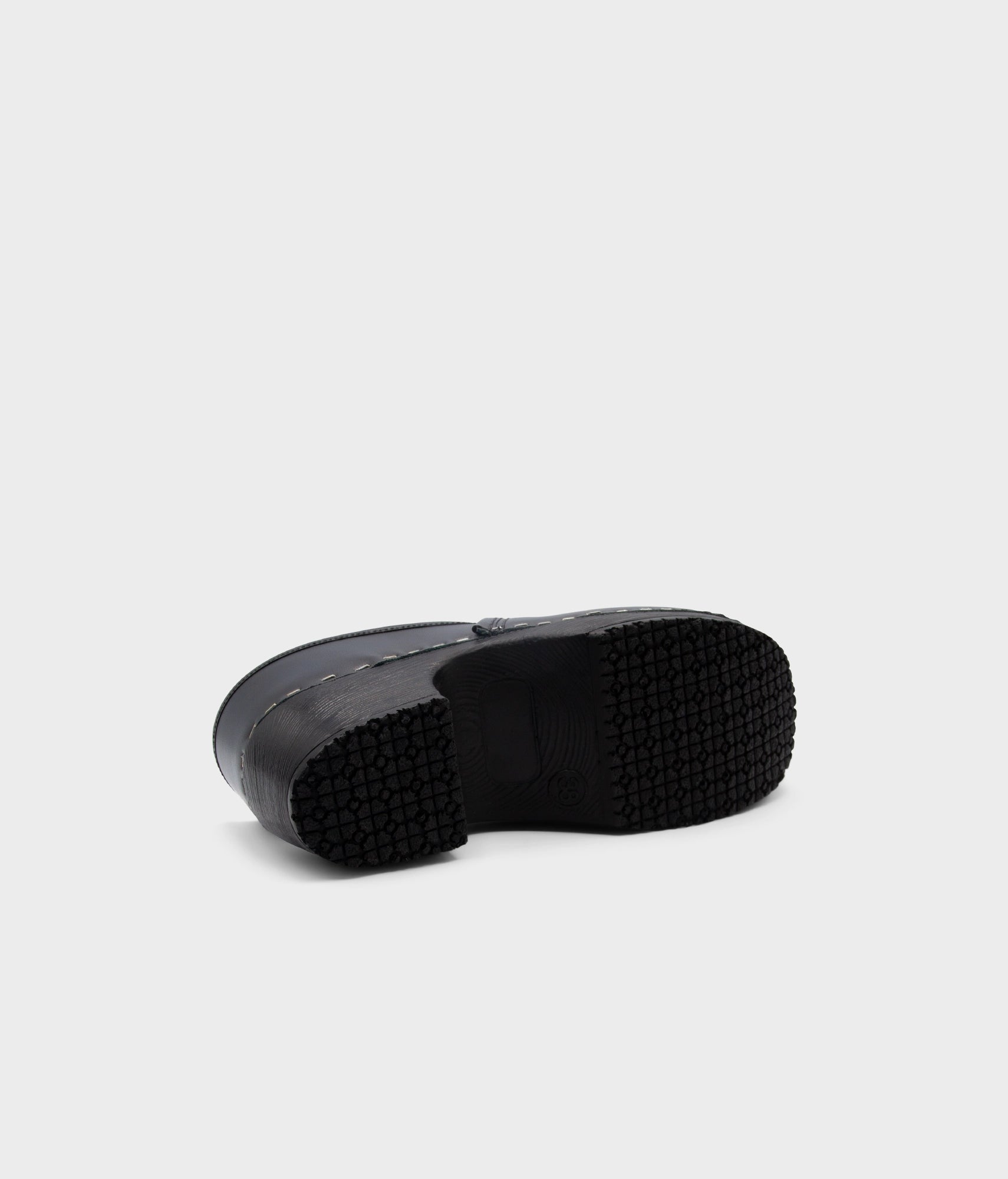 Black rubber sole of a shoe on a light gray background