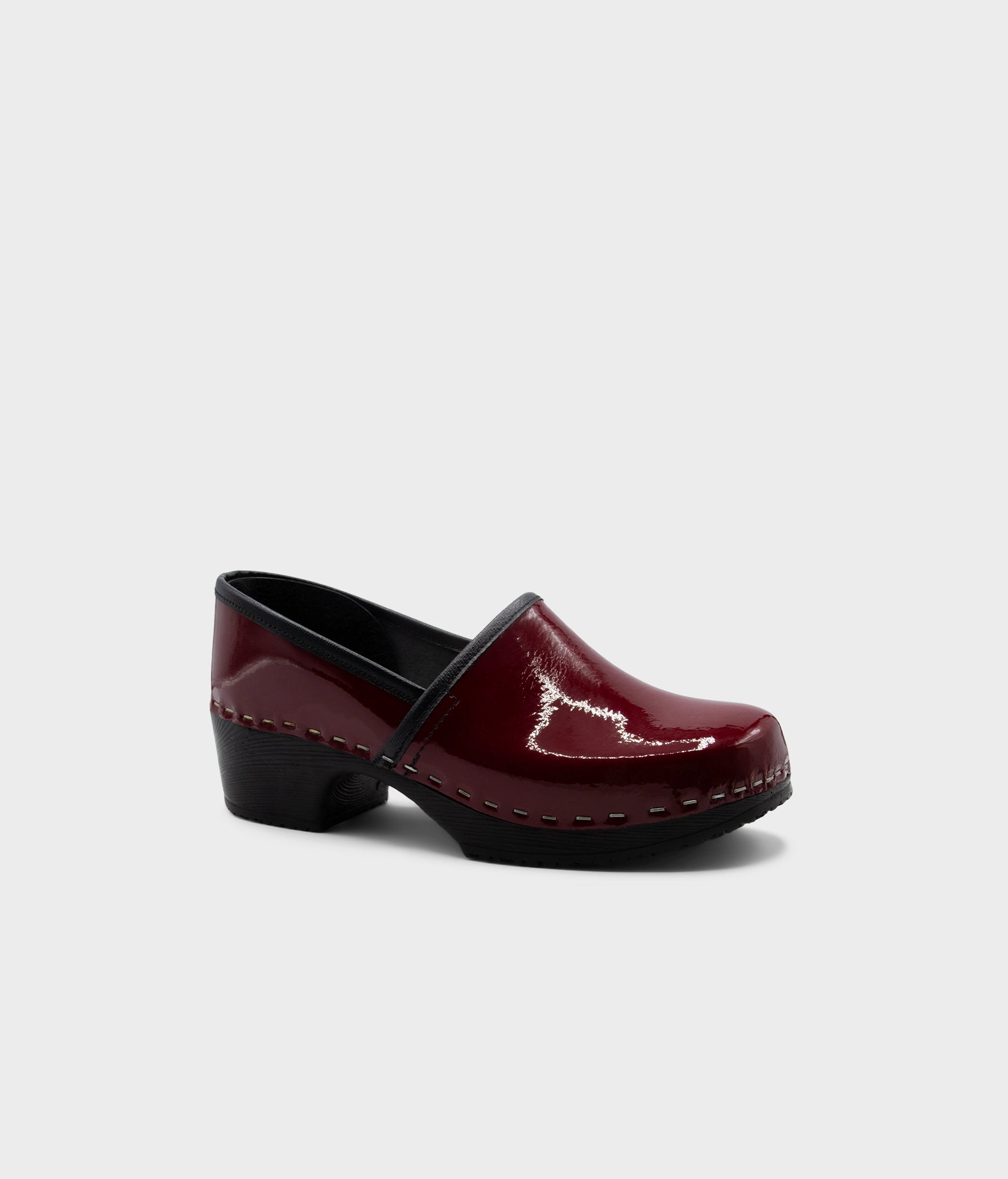 Burgundy clog shoe on a light gray background