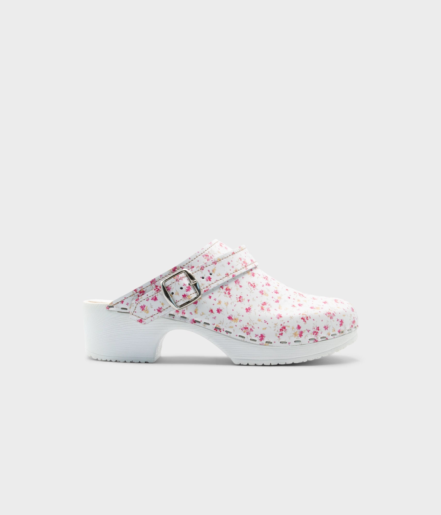 White clog shoe with floral pattern on a light gray background