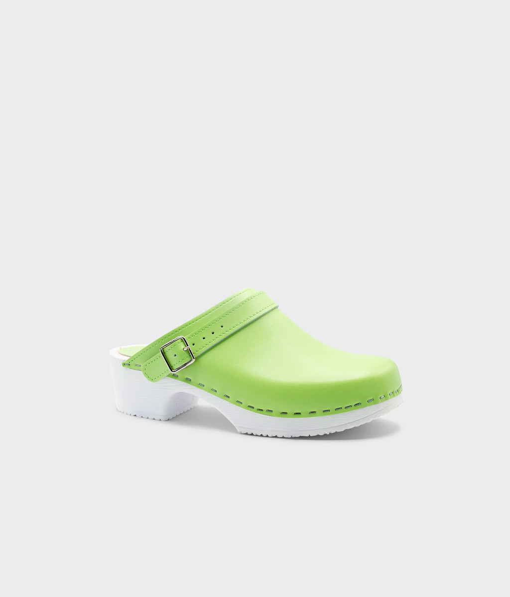 Green clog shoe with a white sole on a light gray background