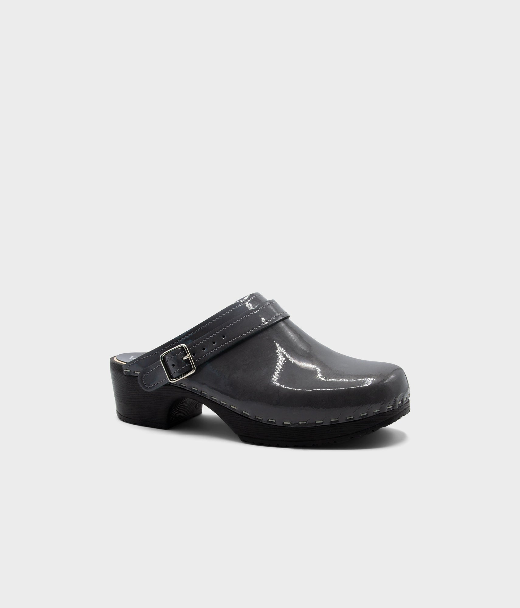 Grey clog shoe with a strap on a light gray background