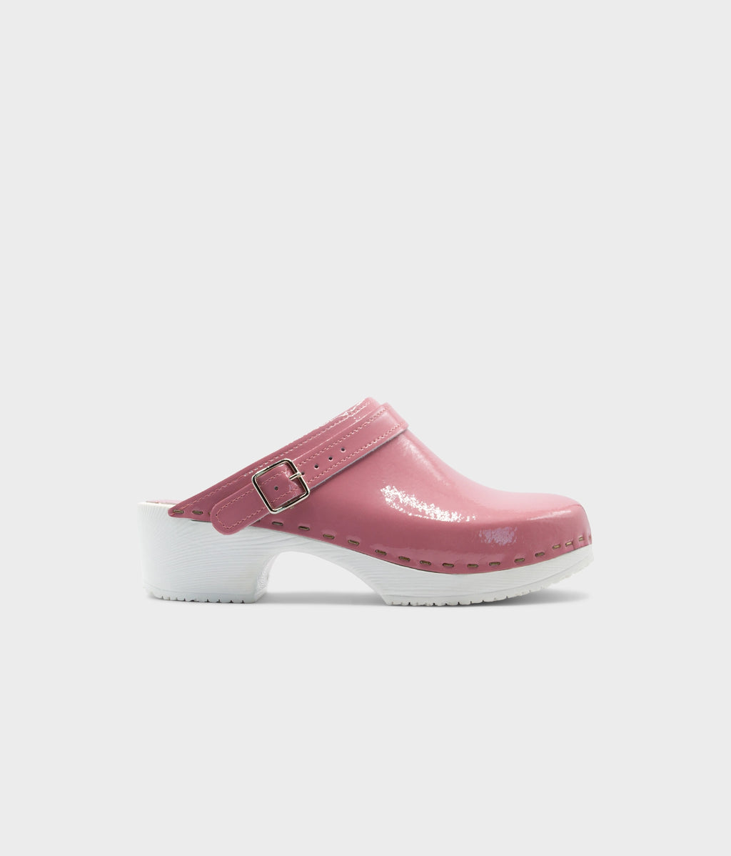 Pink clog shoe with a white sole on a light gray background