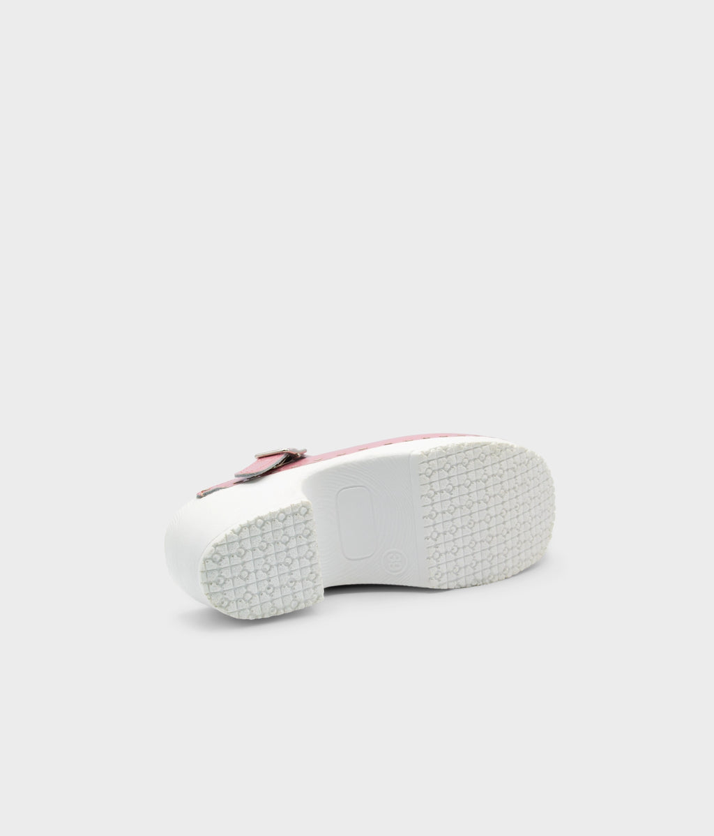 White sneaker with a red sole on a light gray background