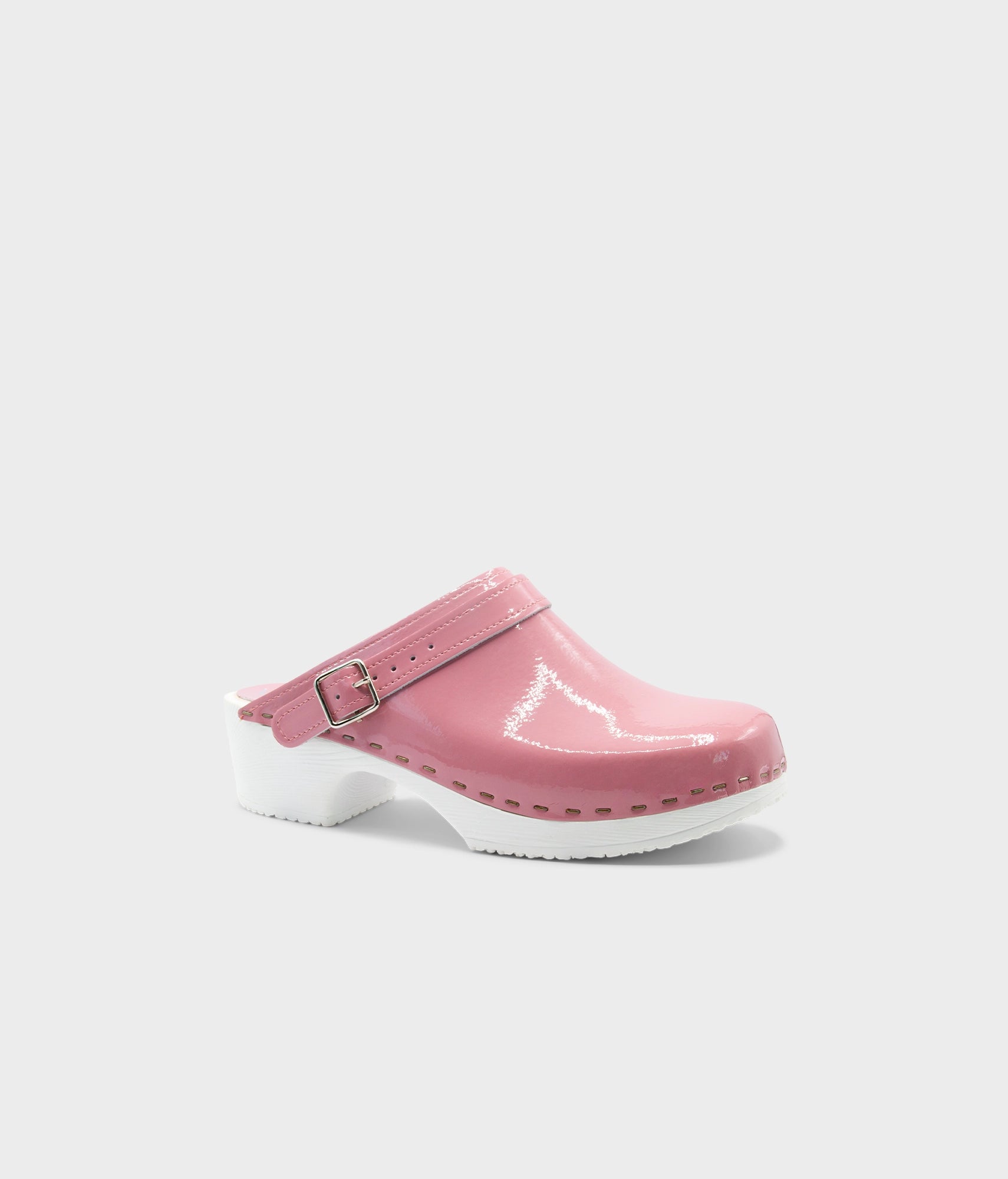 Pink clog shoe with a strap on a white background