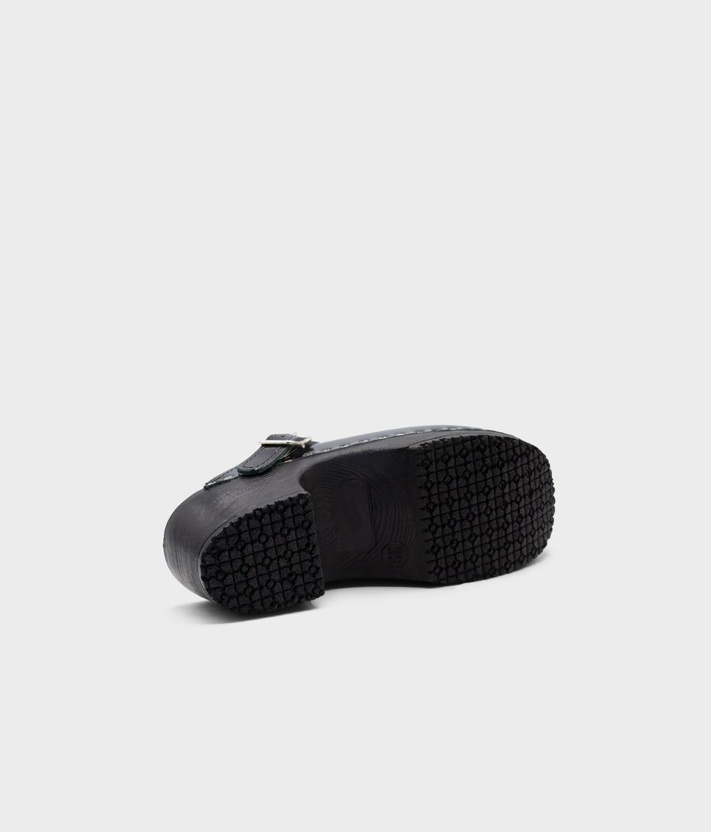 Black rubber sole of a shoe on a light gray background