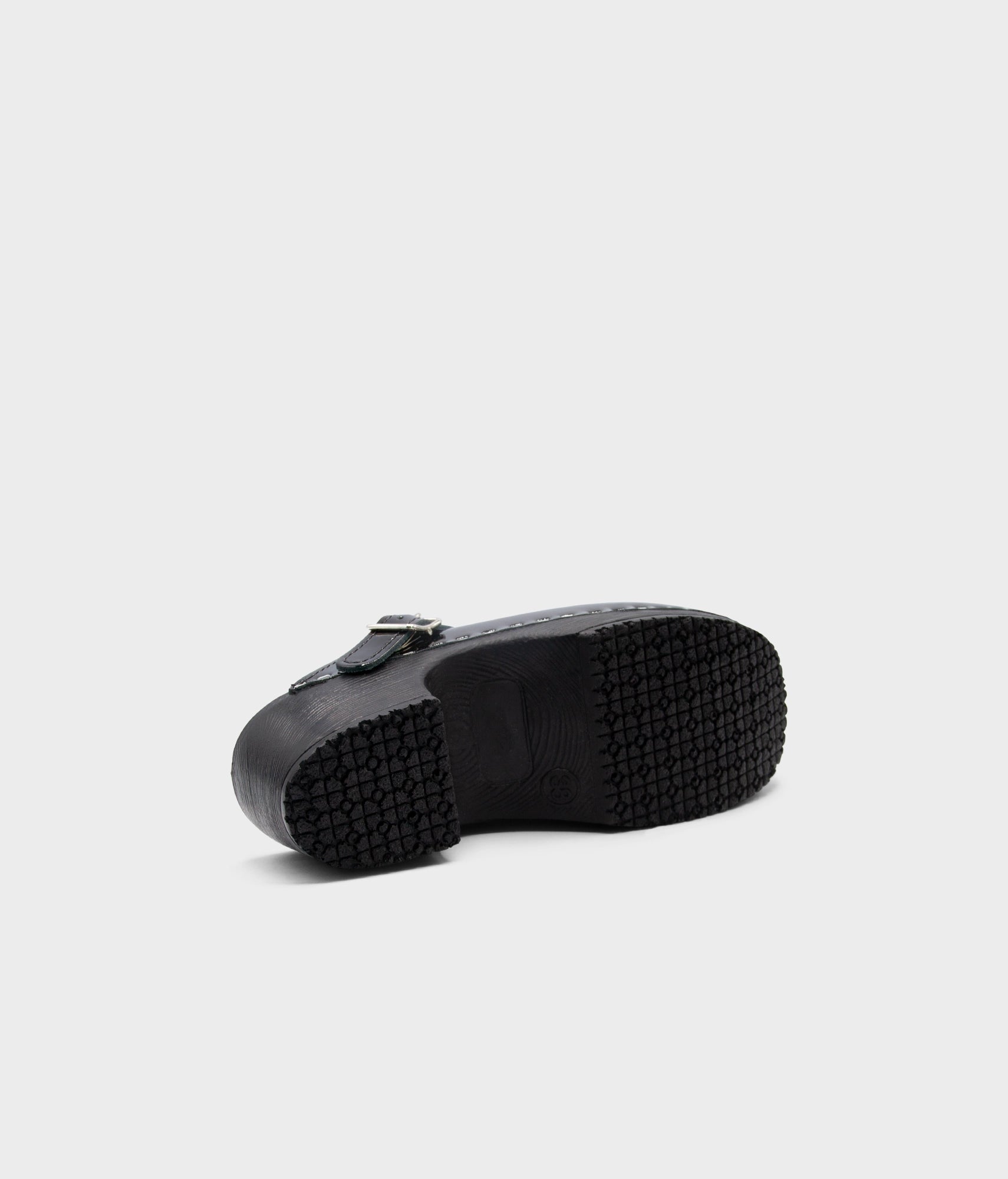 Black rubber sole of a shoe on a light gray background