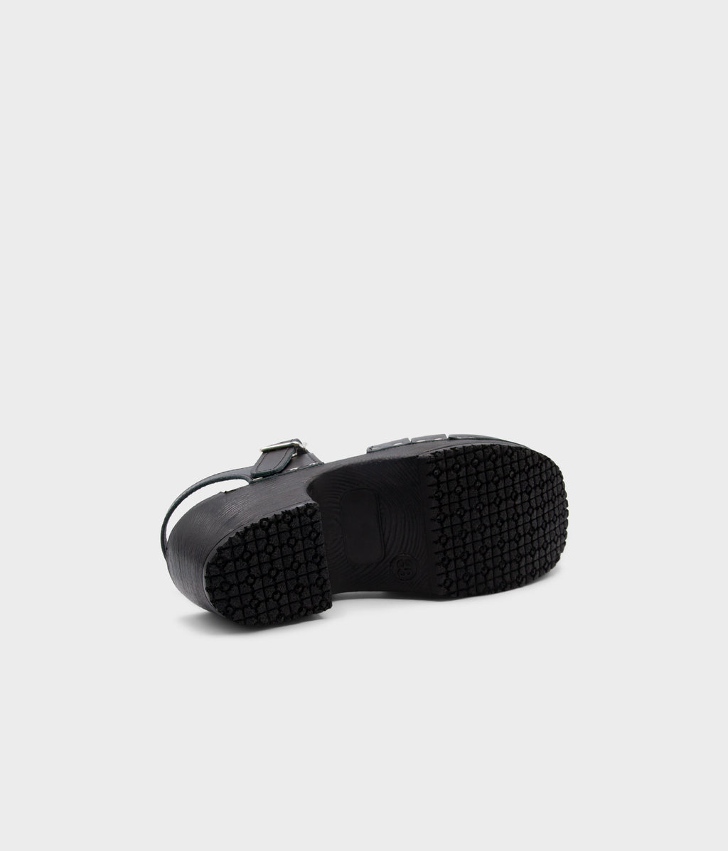 Black rubber sole of a shoe on a light gray background