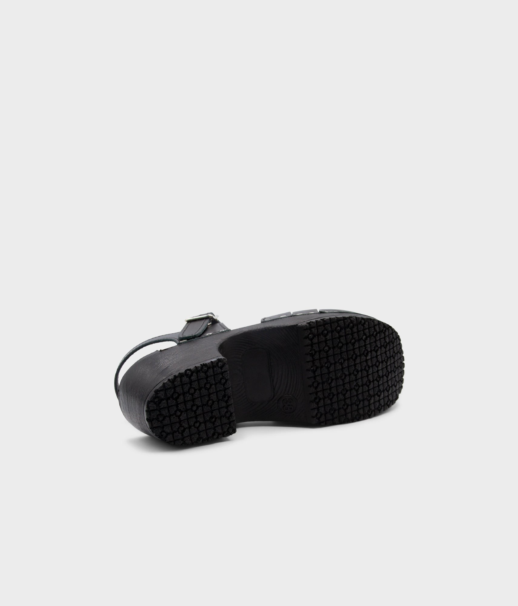 Black rubber sole of a shoe on a light gray background