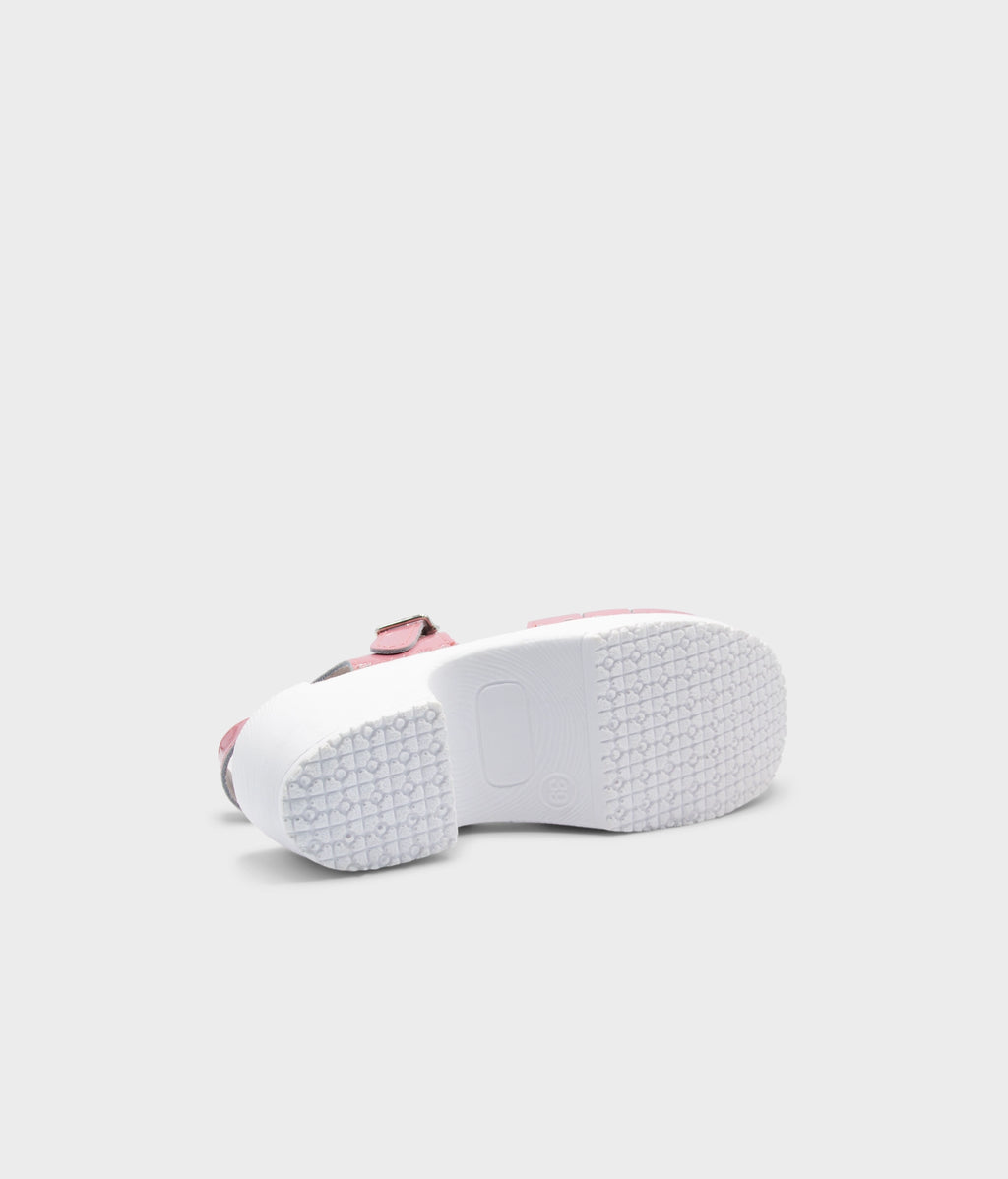White sneaker with pink accents on a light gray background